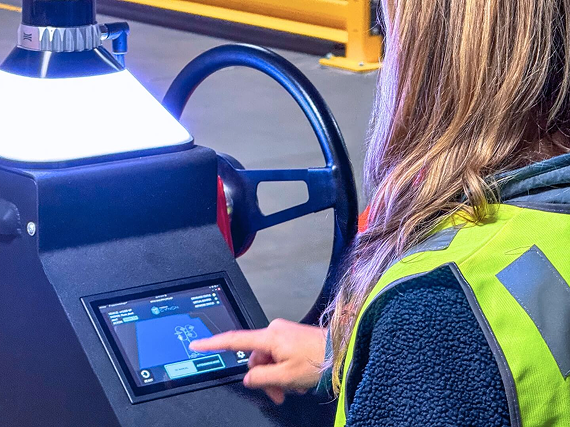Warehouse operator interacting with the Beetronics touchscreen on Cyngn's DriveMod Tugger